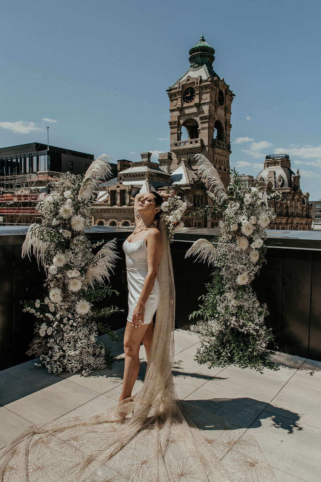 Bride poses in Before by Sarah Seven gown on Milwaukee Rooftop at the Kinn Guesthouse Downtown