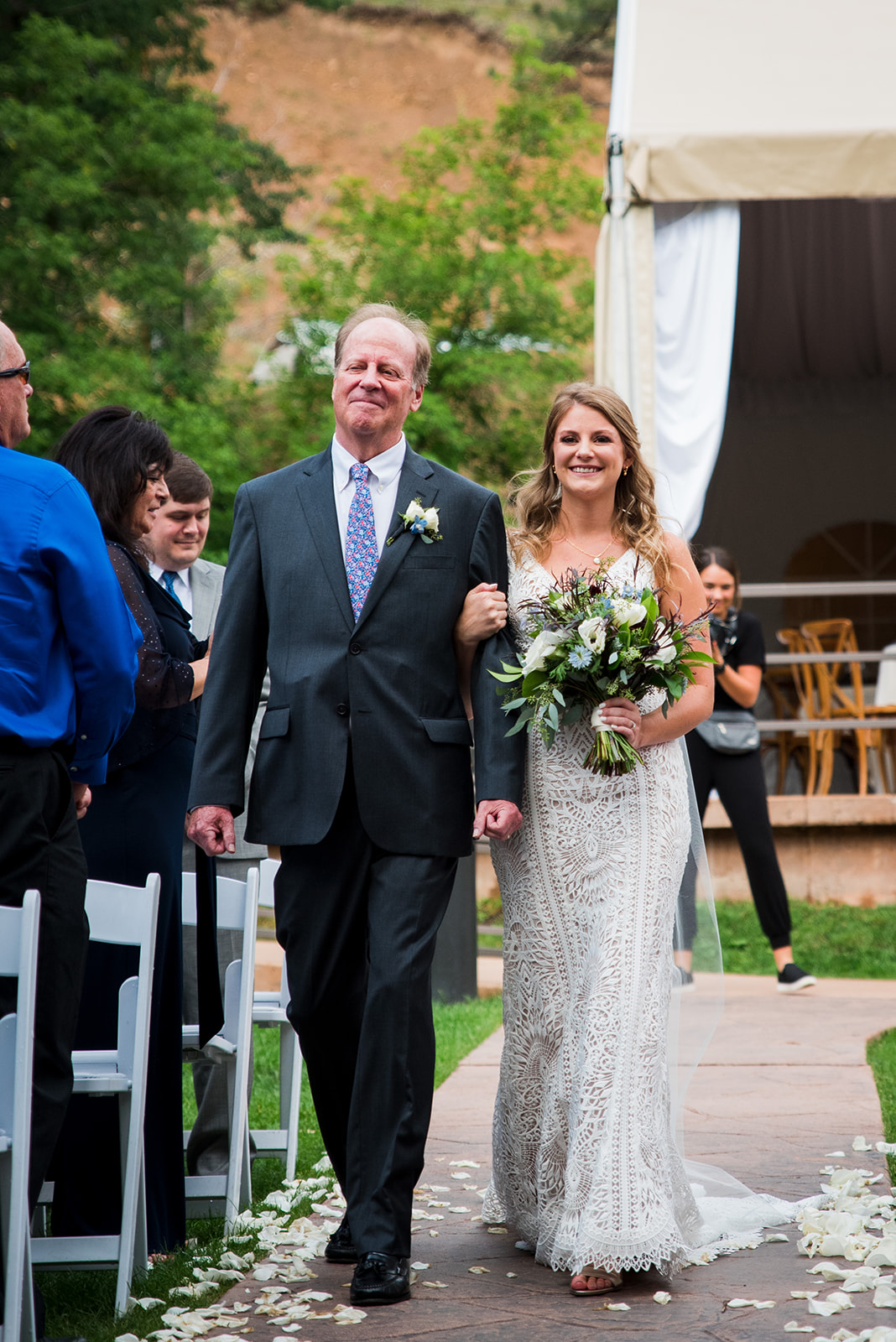 Father of the bride walks his daughter down the aisle toward her groom.