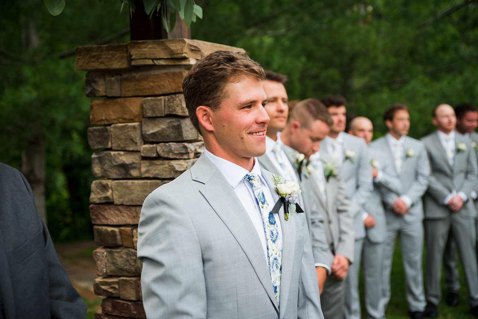 Groom smiles as he waits for bride to walk down the aisle.