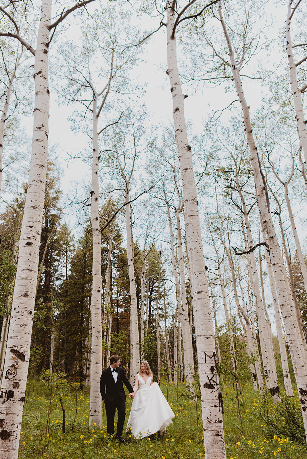 Bride and groom walk through a field in the mountains in Denver, Colorado 