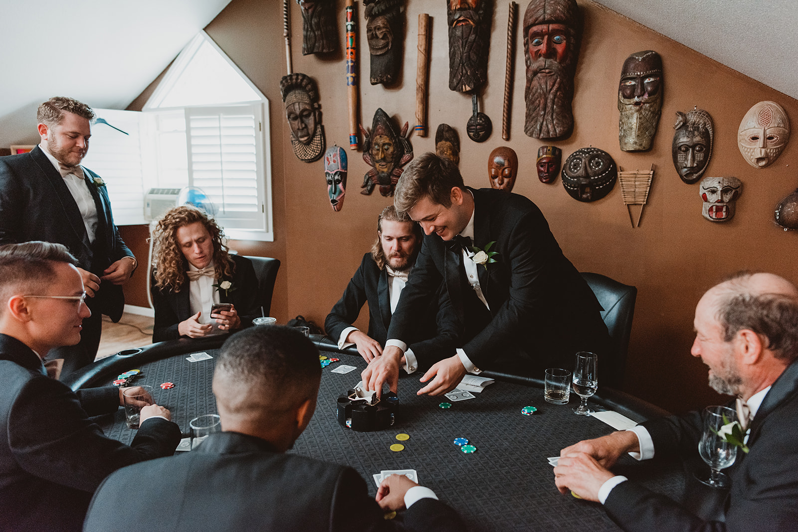 Groom plays poker around a poker table on his wedding day in Denver Colorado 