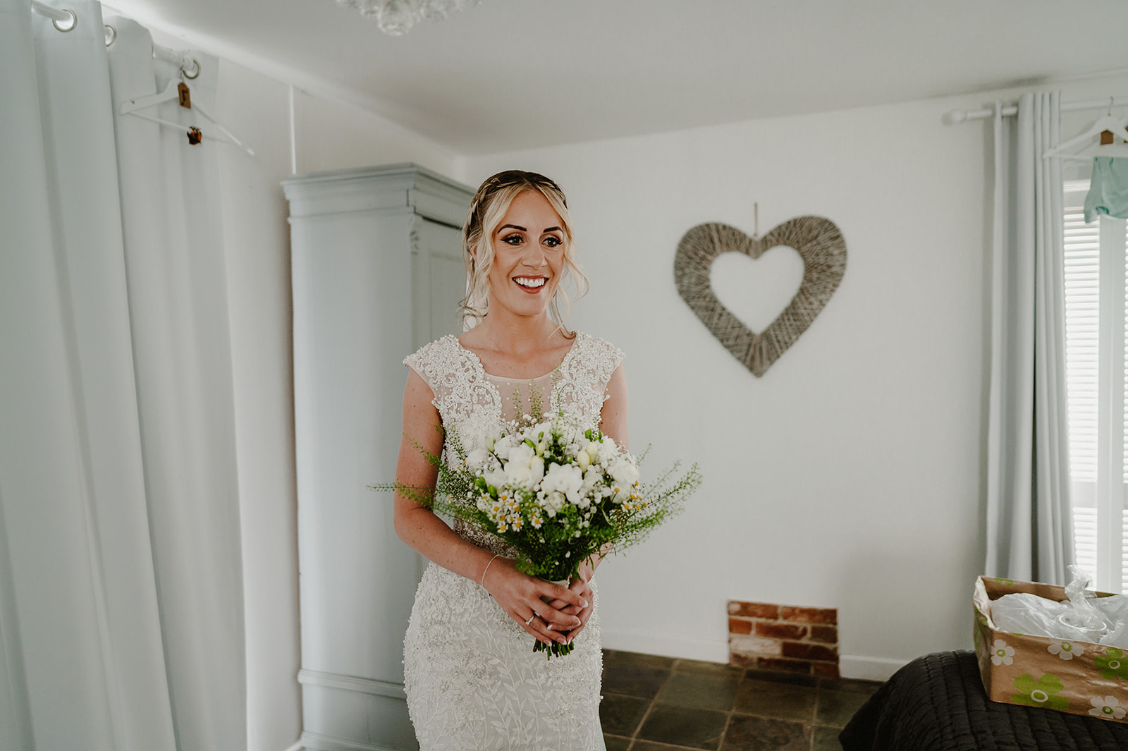 bride at villiers barn holding her flowers smiling indoors before the wedding ceremony