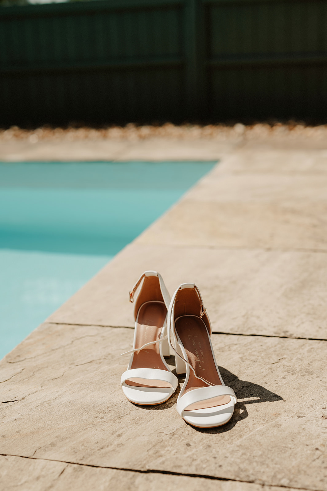photo at villiers barn of white wedding shoes outside on paving by the swimming pool