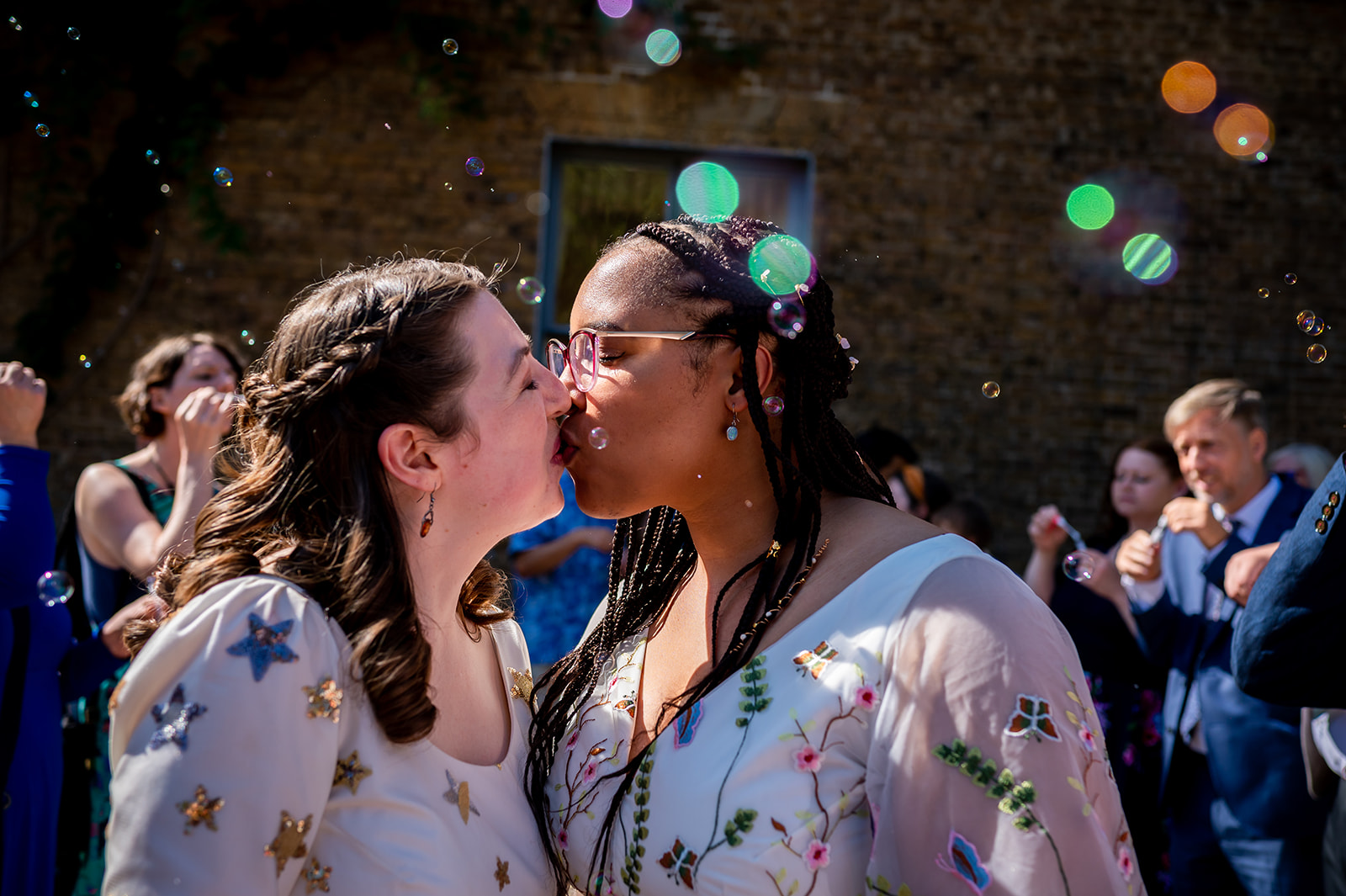 bubble confetti and two brides kissing at Kew Gardens wedding