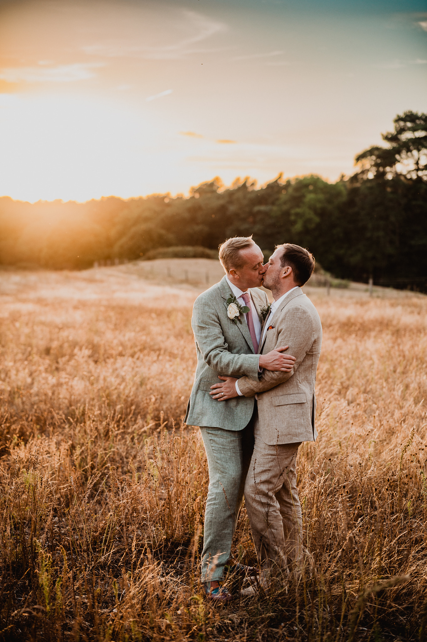 A same sex male couple share a kiss during sunset in the Norfolk countryside