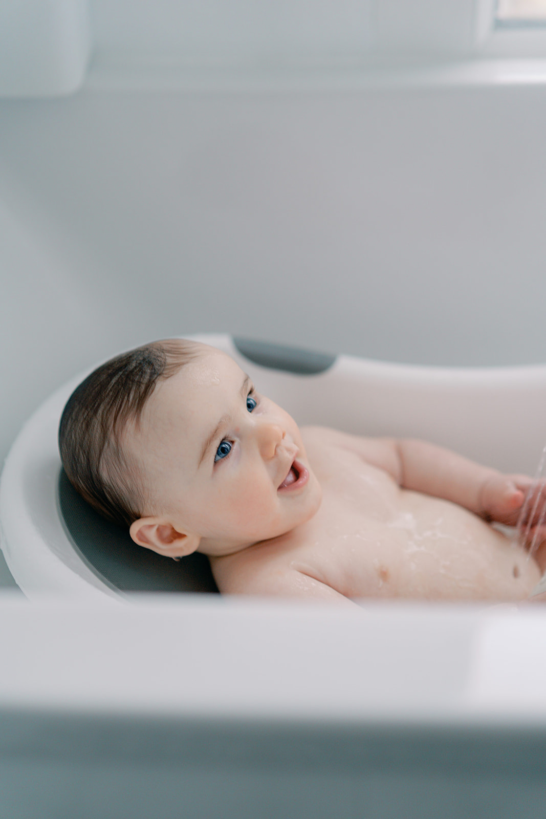 Séance naissance lifestyle Sain Mandé Val de Marne avec un bébé de 8 mois, le moment du bain.