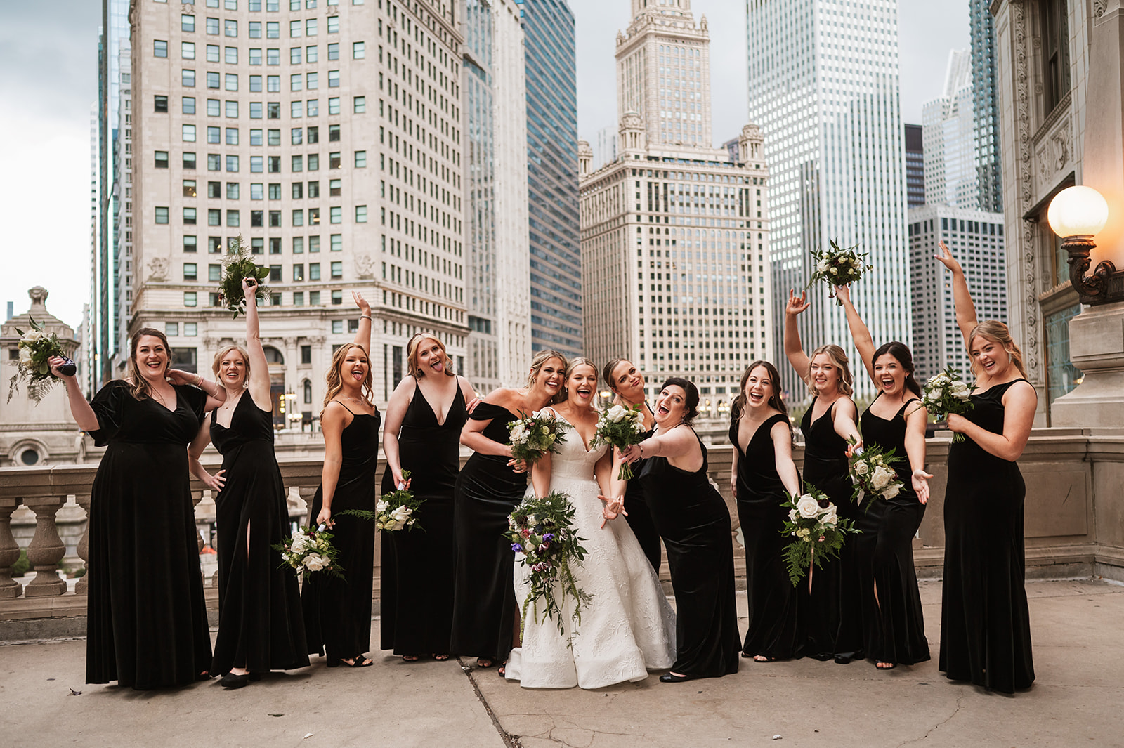 Bridesmaids and a bride at the end of the winter on riverwalk by the Wrigley building chicago