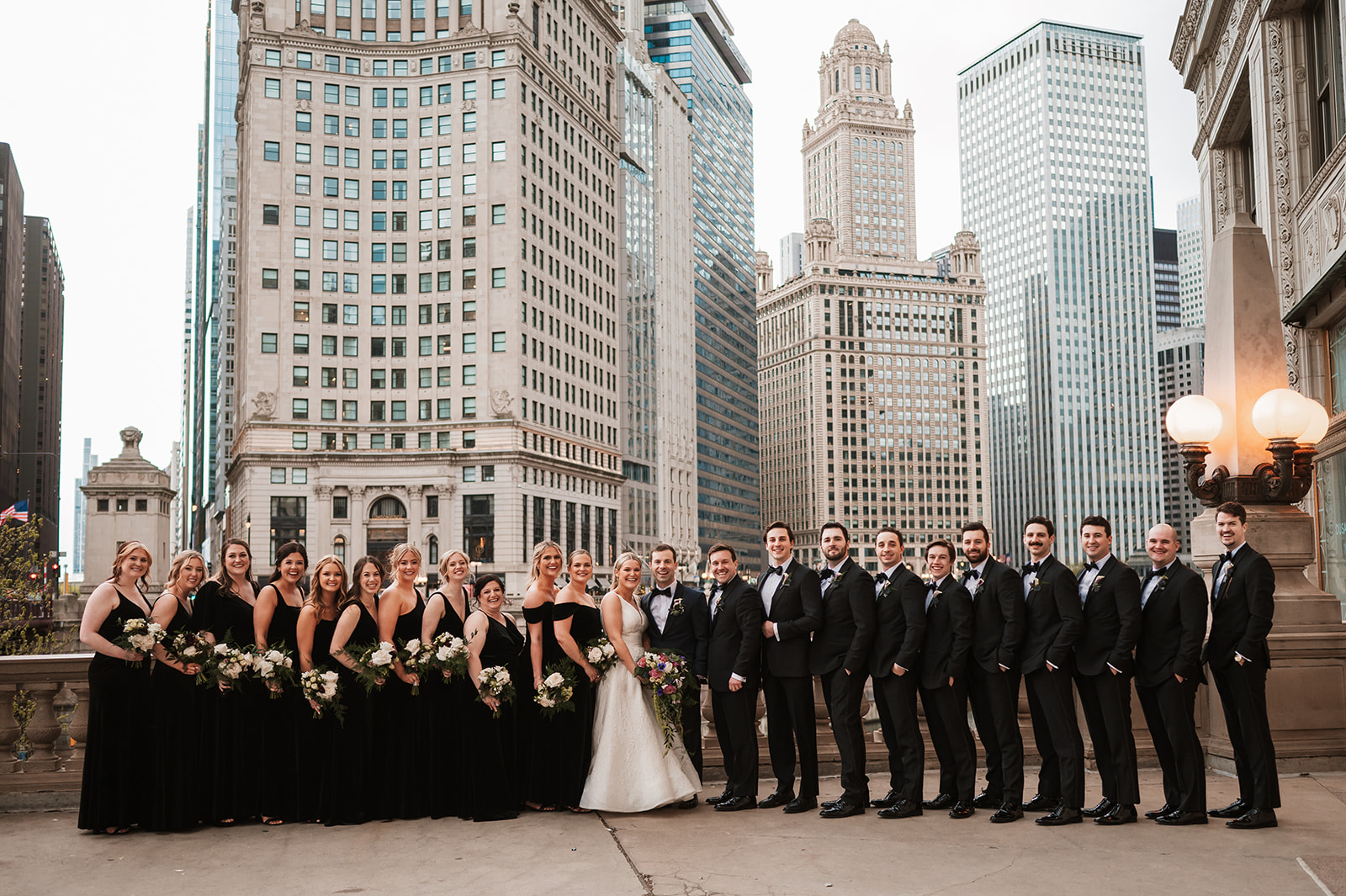 wedding party at the end of the winter on riverwalk by the Wrigley building chicago