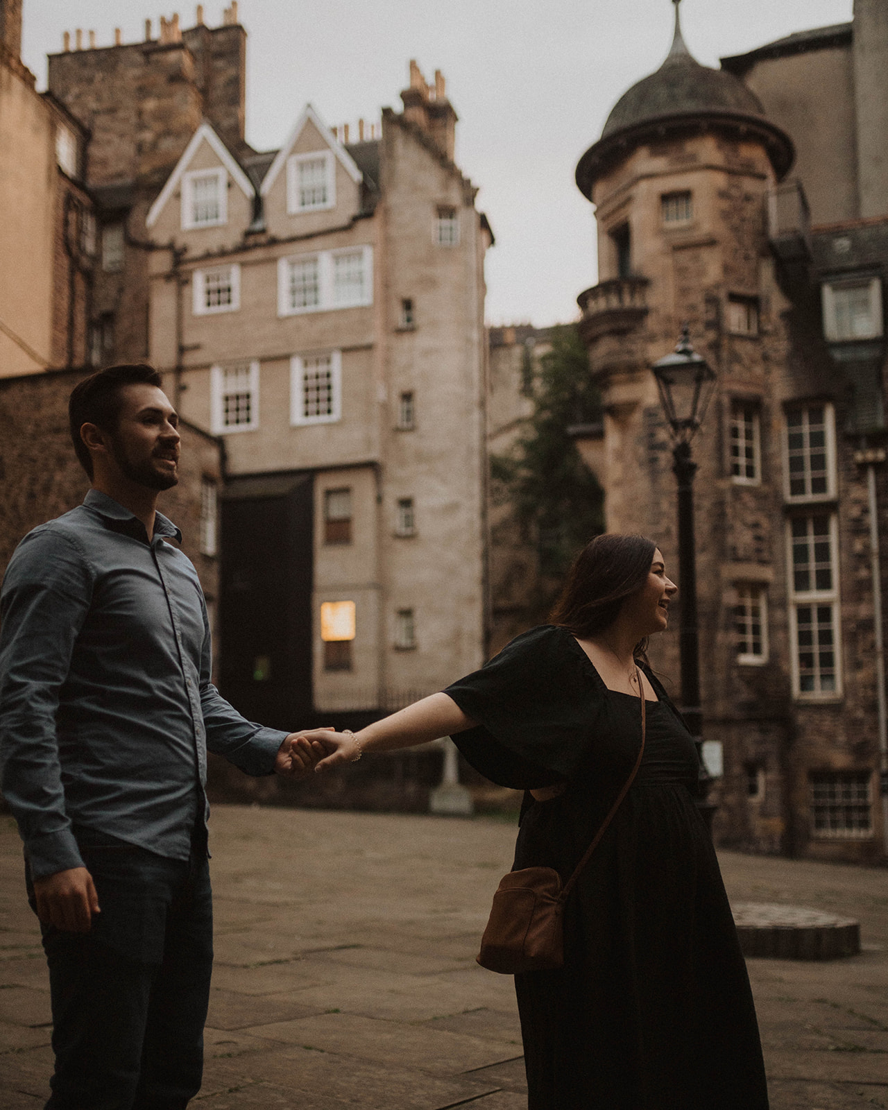 Couple dance in Advocate's Close on Royal Mile during maternity photo shoot
