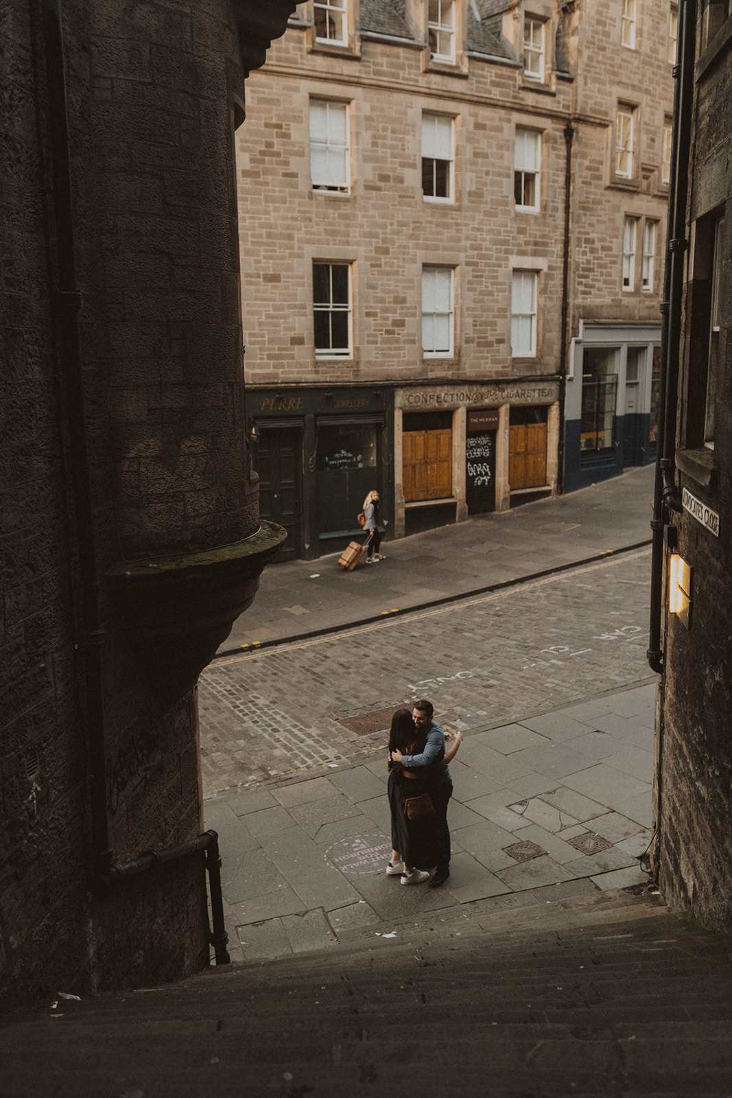 Couple walk up to the Royal Mile in Edinburgh during maternity photoshoot