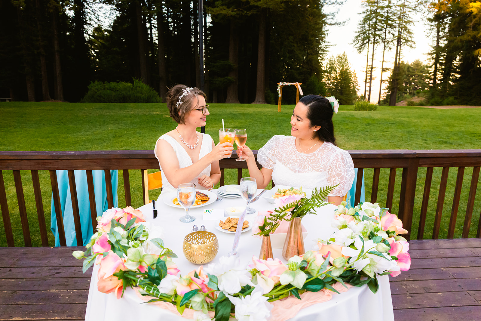 two brides cheers at their intimate outdoor wedding reception
