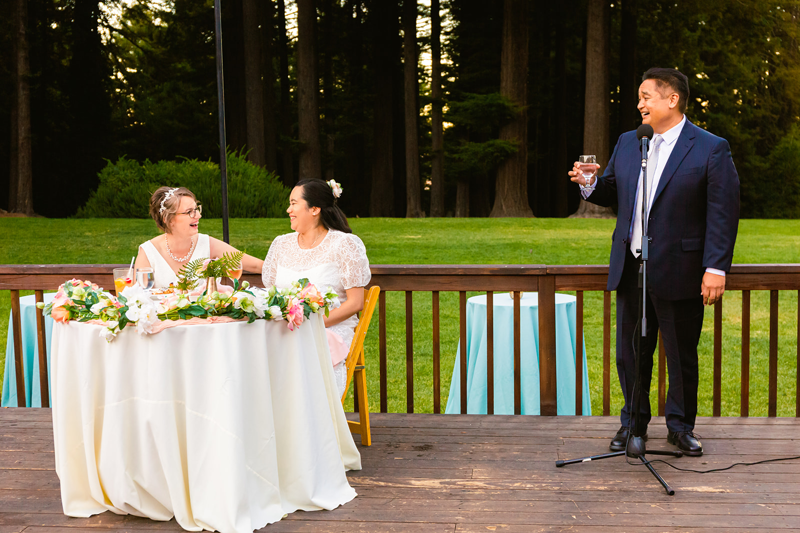 two brides enjoy toasts at their outdoor intimate wedding reception