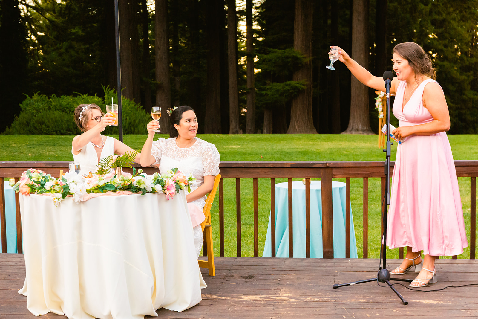 two brides enjoy toasts at their outdoor intimate wedding reception