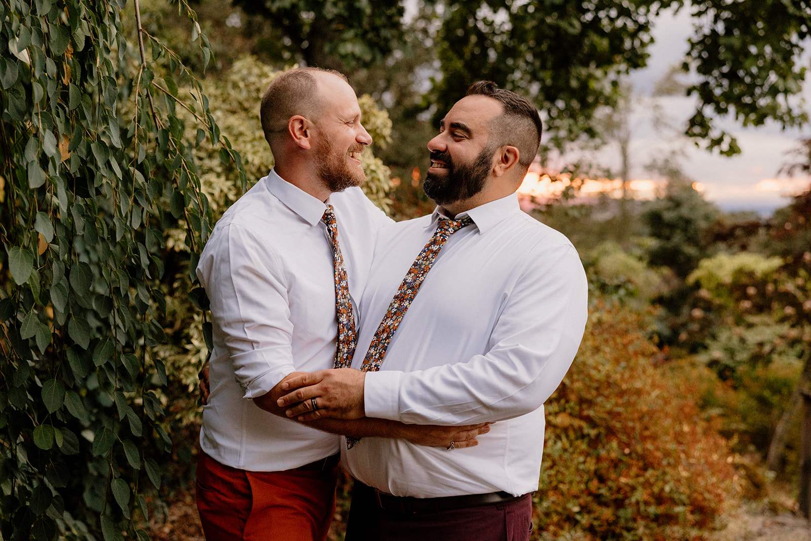 Two grooms pose for sunset photos at their Oregon Garden wedding reception. 