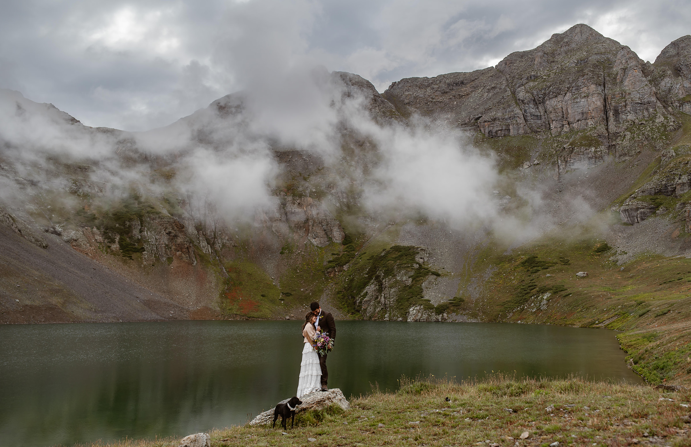 A couple who eloped at Clear Lake near Ouray Colorado embrace after saying their vows in front of a stunning Alpine lake