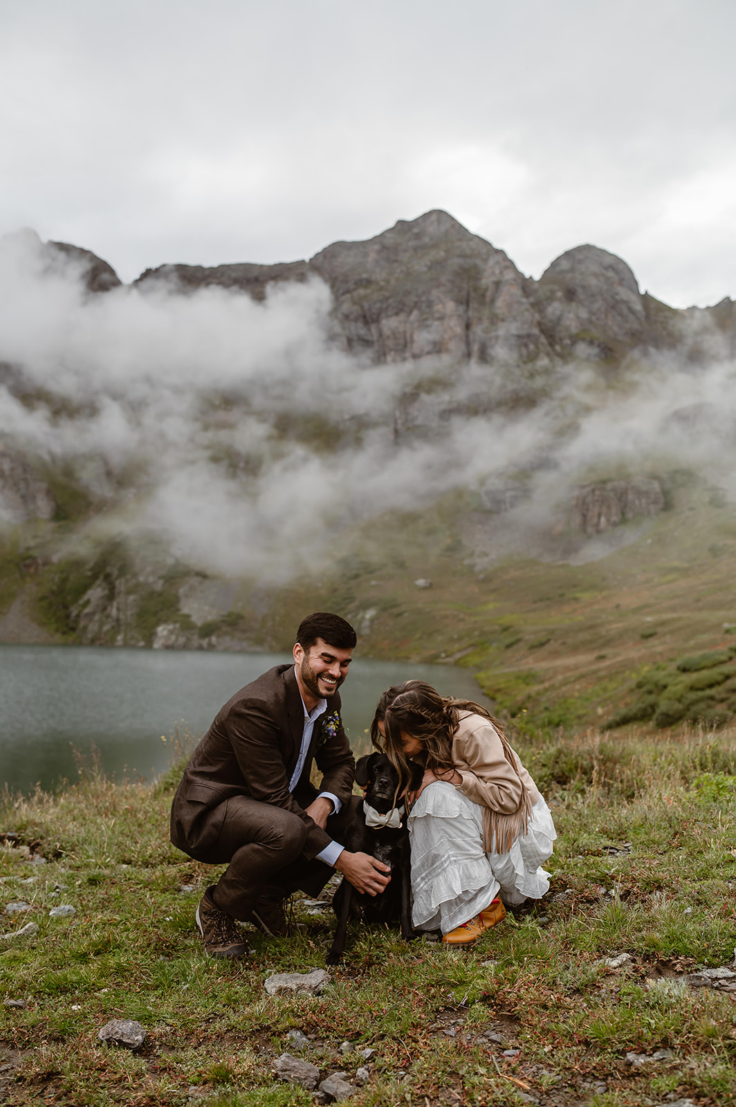 Couple embracing their dog after they said their vows in front of an alpine lake near Ouray Colorado