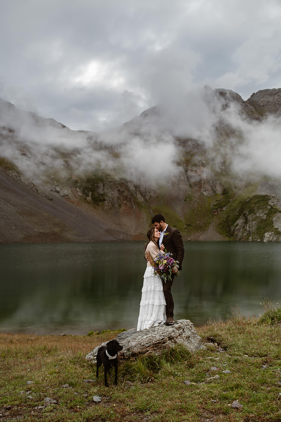 A couple who eloped at Clear Lake near Ouray Colorado embrace after saying their vows in front of a stunning Alpine lake