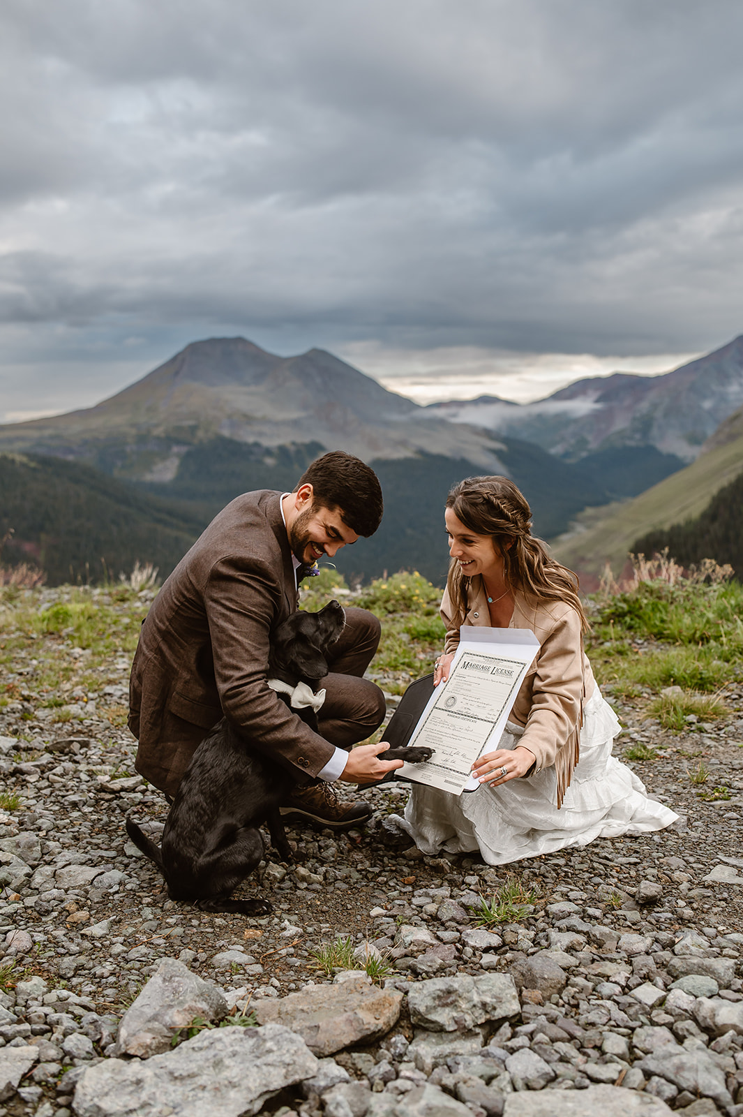 Couple having their dog sign their marriage license after during their off-road adventure elopement at Clear lake in Co