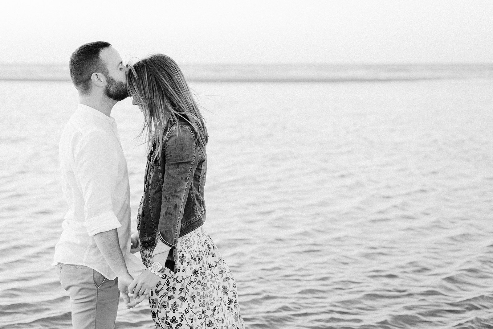 Séance couple sur la plage, les amoureux s'embrassent