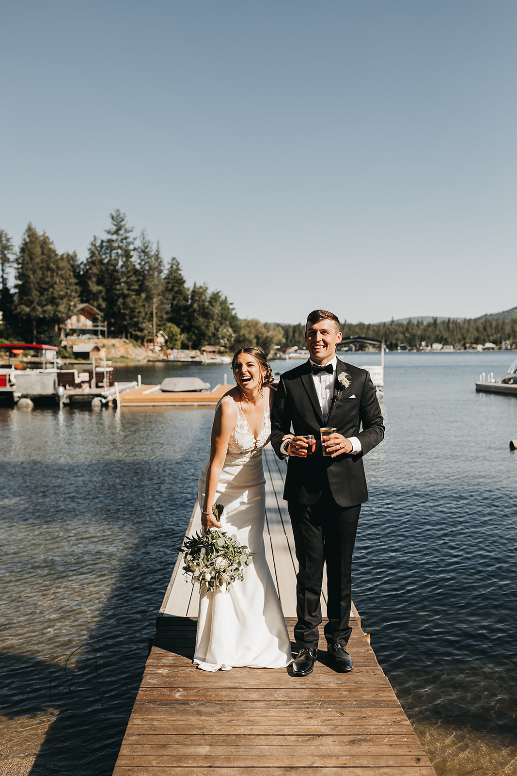 Bride and groom celebrate after on private dock private lake house lake front wedding.