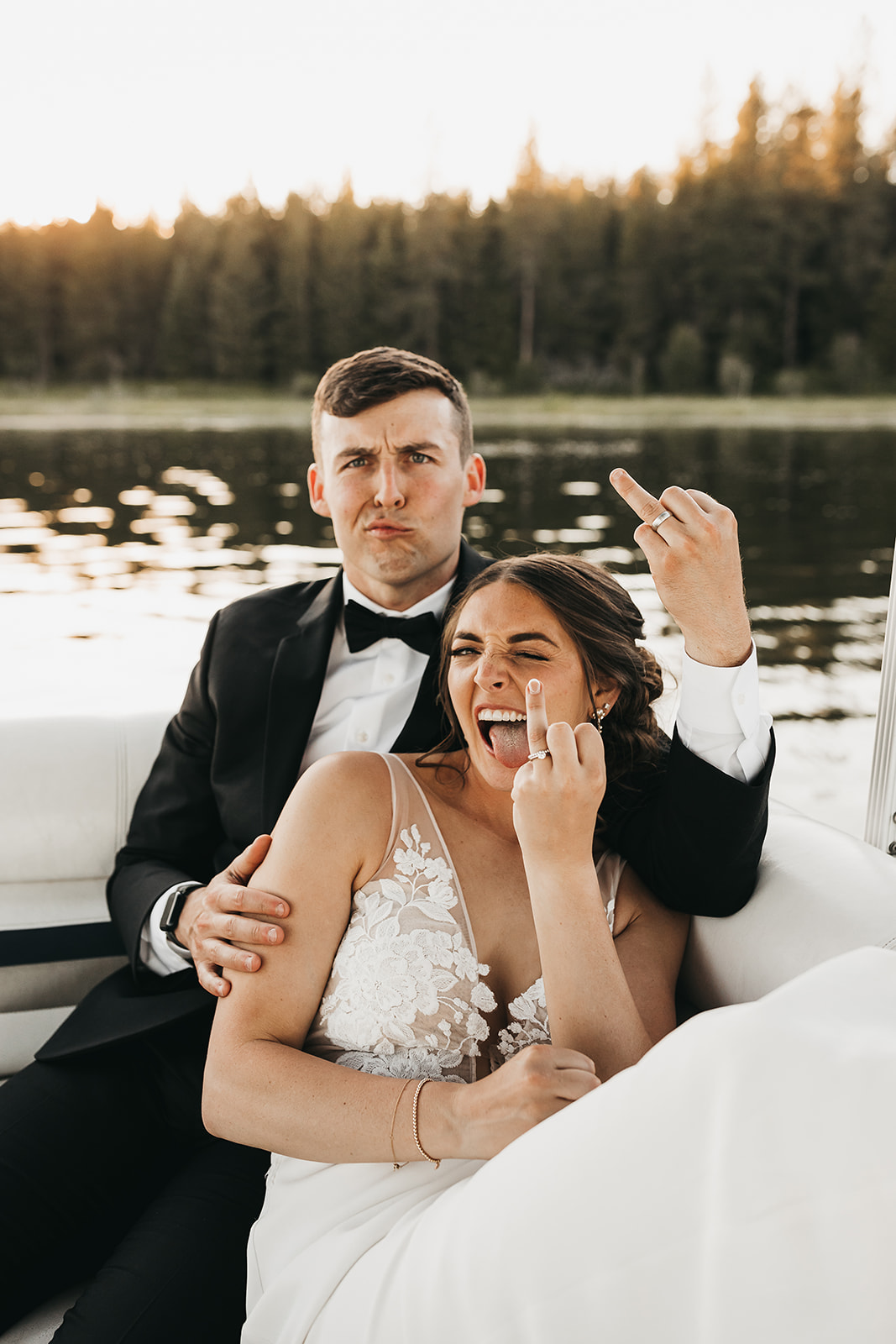 Bride and groom having fun on the family pontoon boat at private lake house wedding.