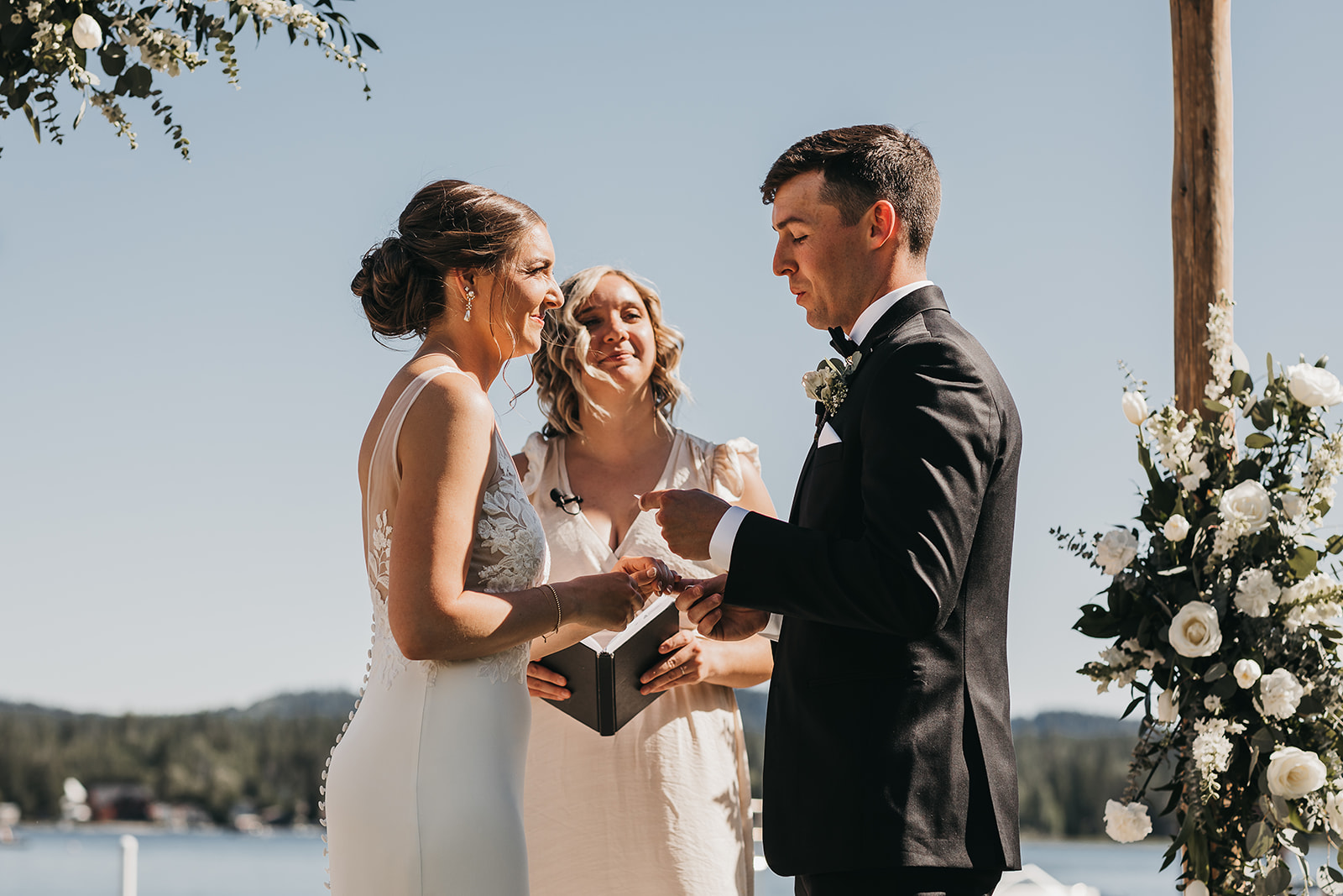 Groom reading his vows to bride during ceremony with lake view at the private family lake house.