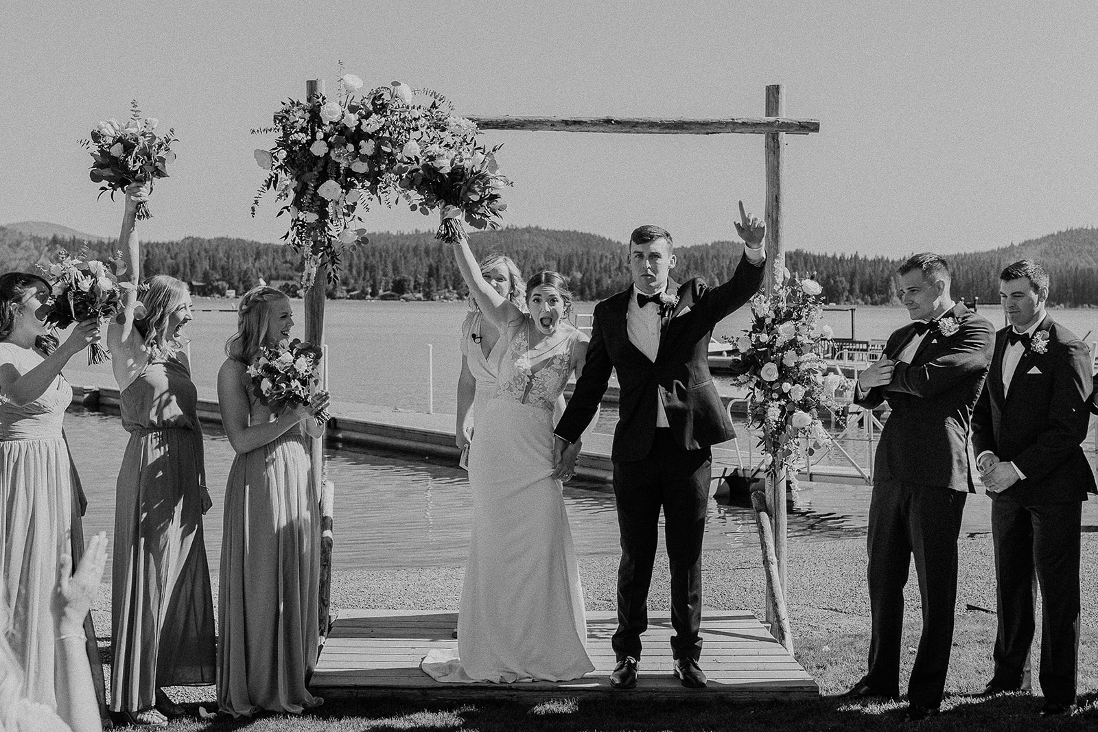 Bride and groom celebrate after first kiss as husband and wife at private lake house lake front wedding.