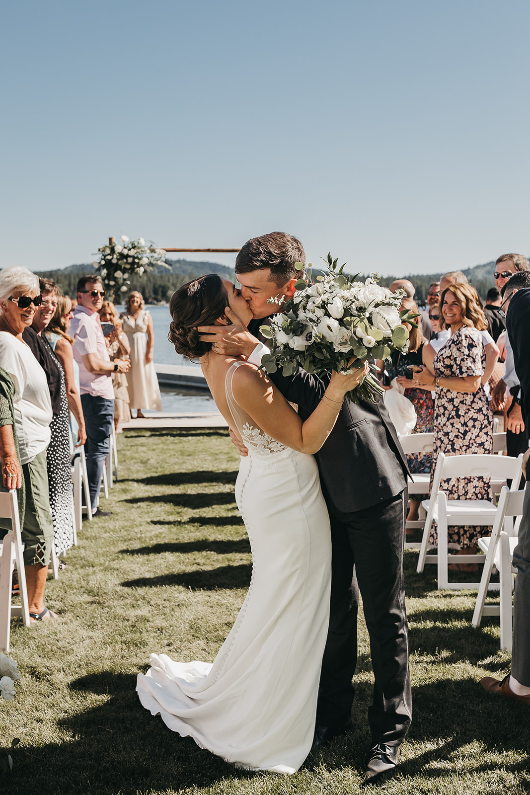 Bride and groom share first kiss as husband and wife at private lake house lake front wedding.