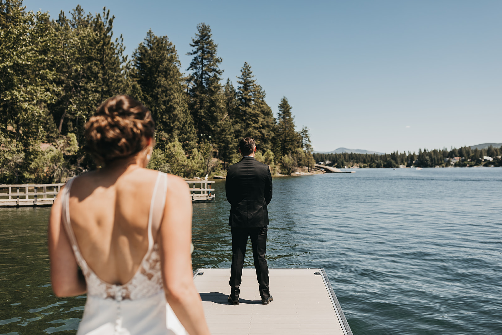 Bride walking up to groom on private dock for first look before the wedding ceremony on lake front property.