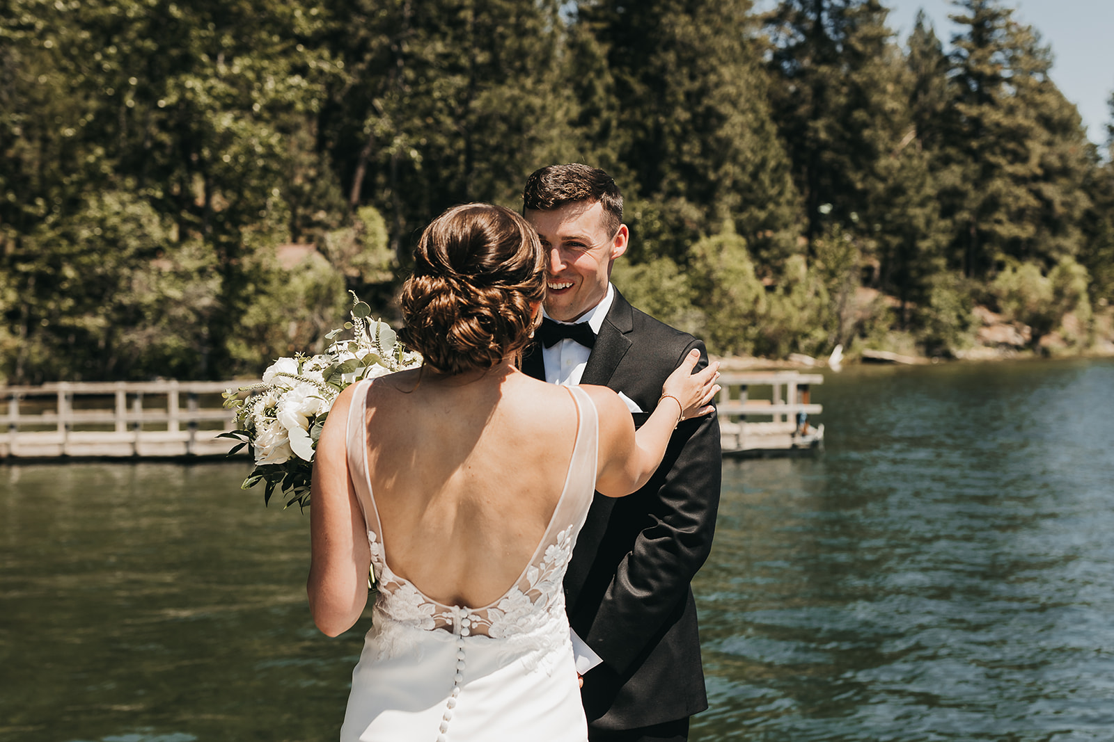 Bride and groom first look on private dock before the wedding ceremony on lake front property.