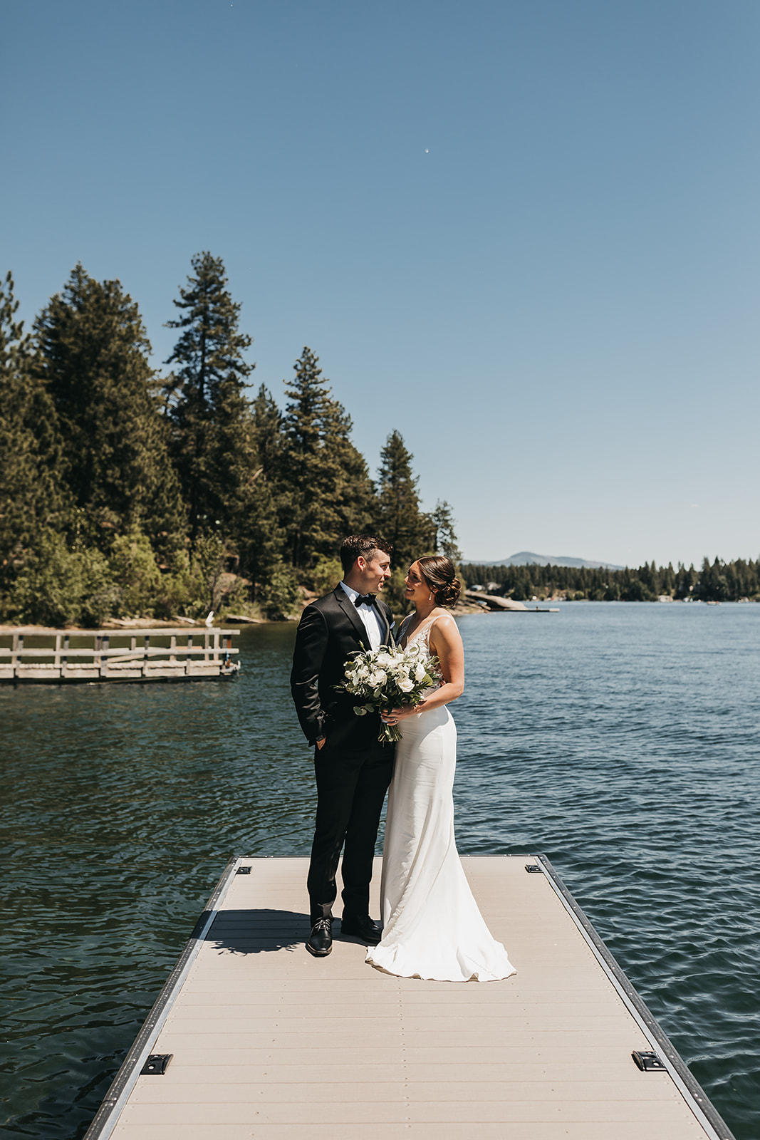 Bride and groom intimate moment on private dock before the wedding ceremony on lake front property.