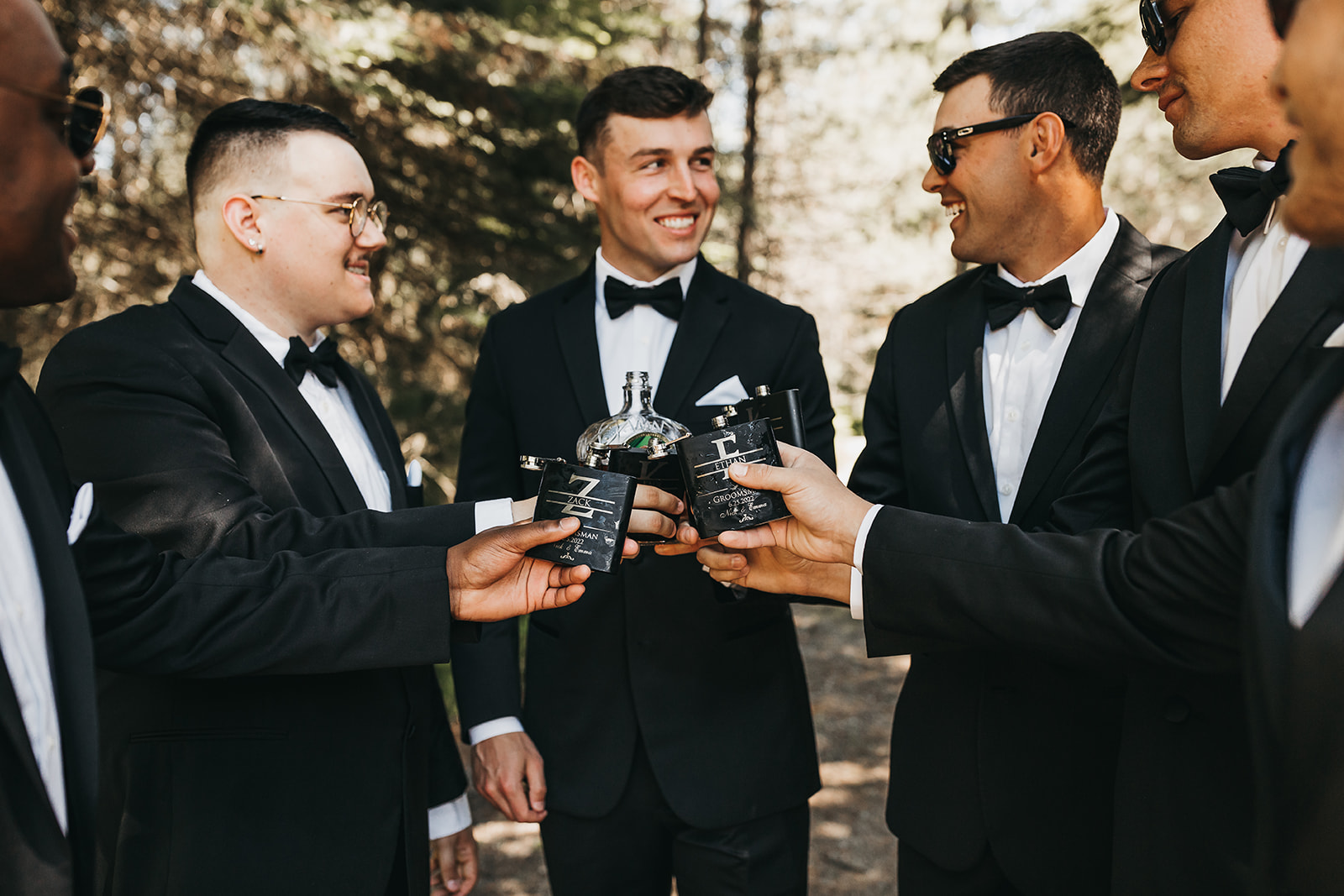Groom and groomsmen sharing a drink before the wedding with custom wedding flasks.
