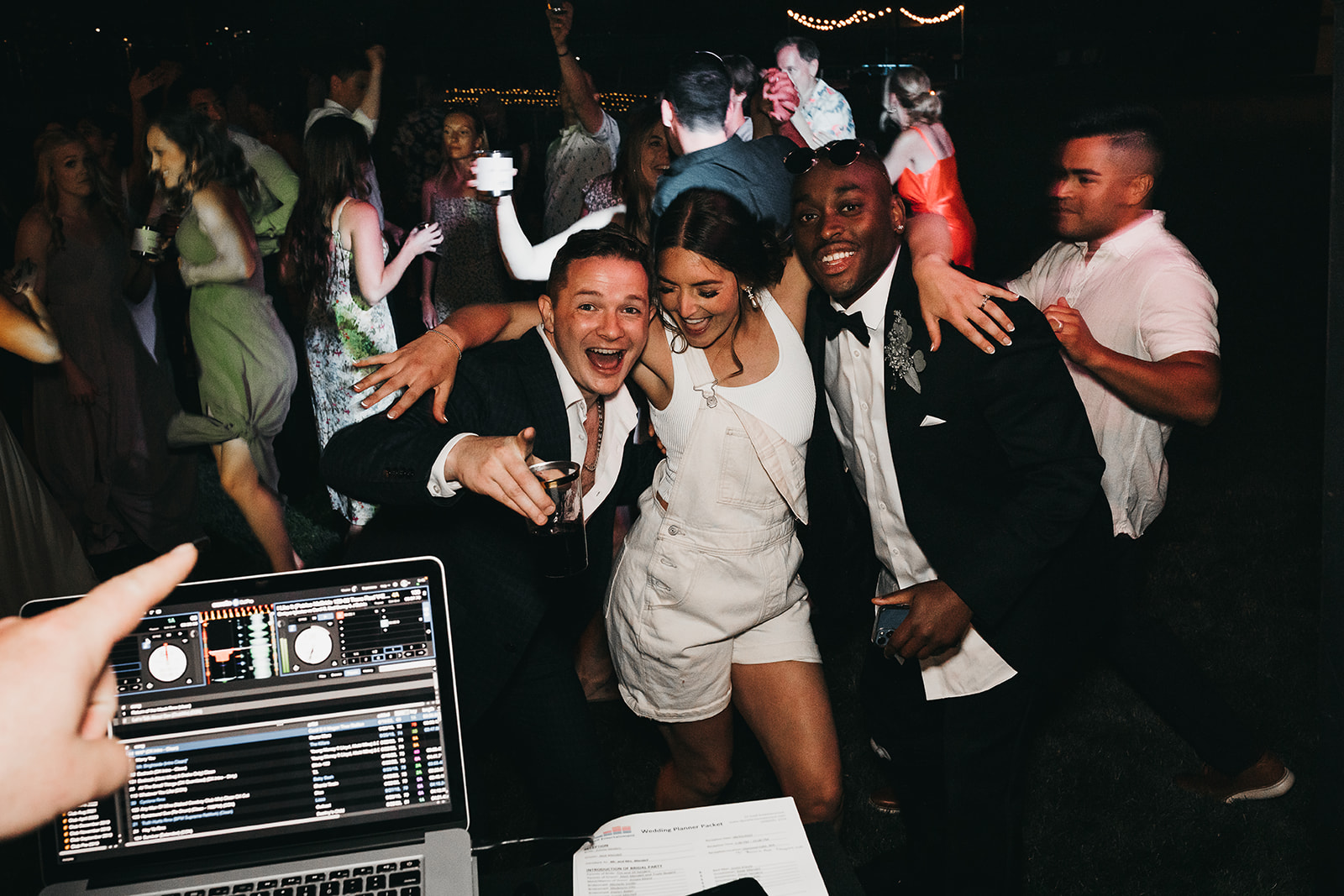 Wedding guest and bride having fun during wedding reception with the DJ at private family lake house. 