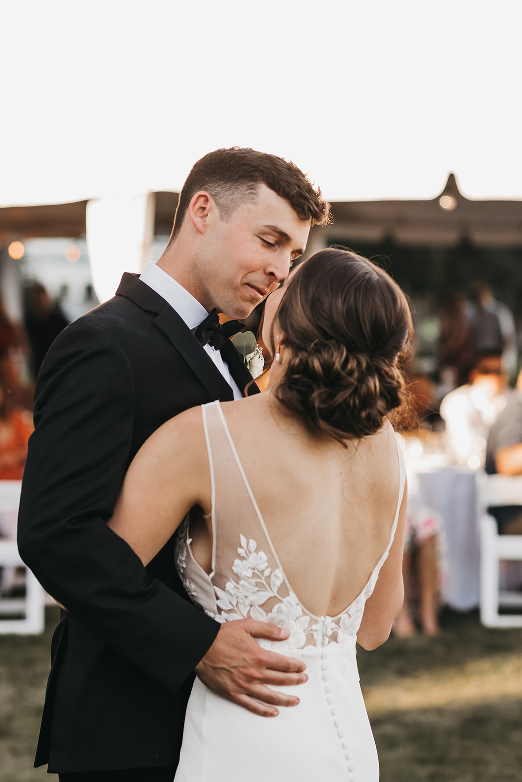 Bride and groom share first dance as husband and wife at private lake house wedding. 