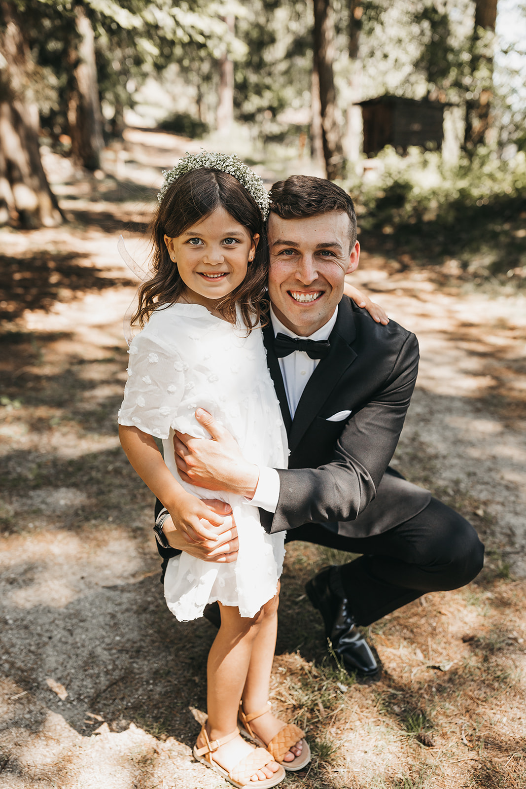Groom with flower girl at private lake house wedding.