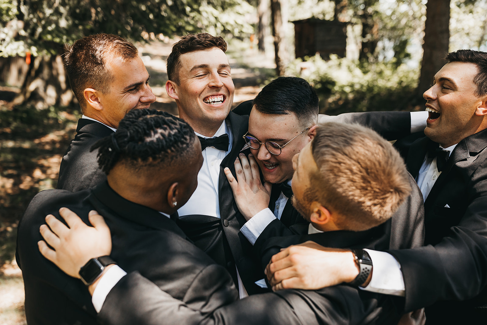 Groom and groomsmen messing around before wedding ceremony at private lake house.