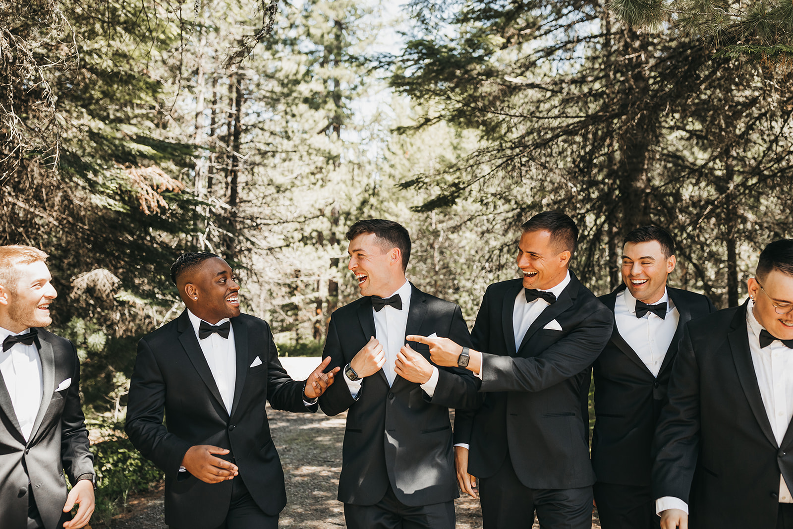 Groom and groomsmen talking before wedding ceremony at private lake house.
