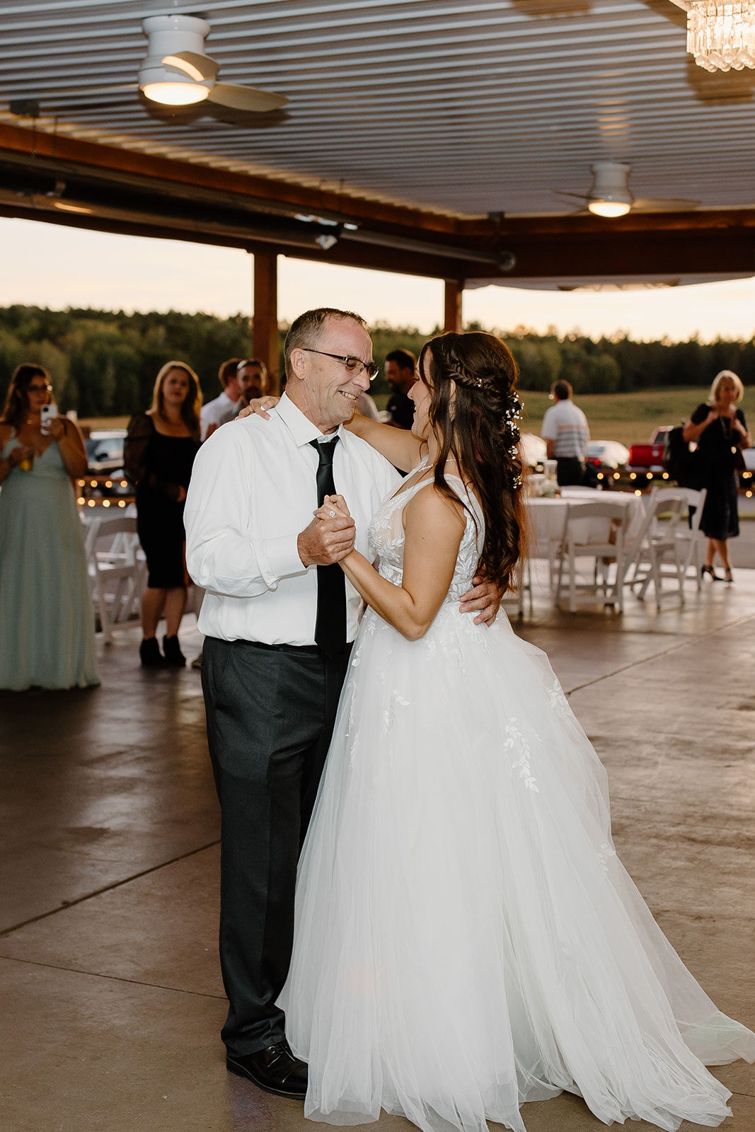 Bride and her father dance underneath lights