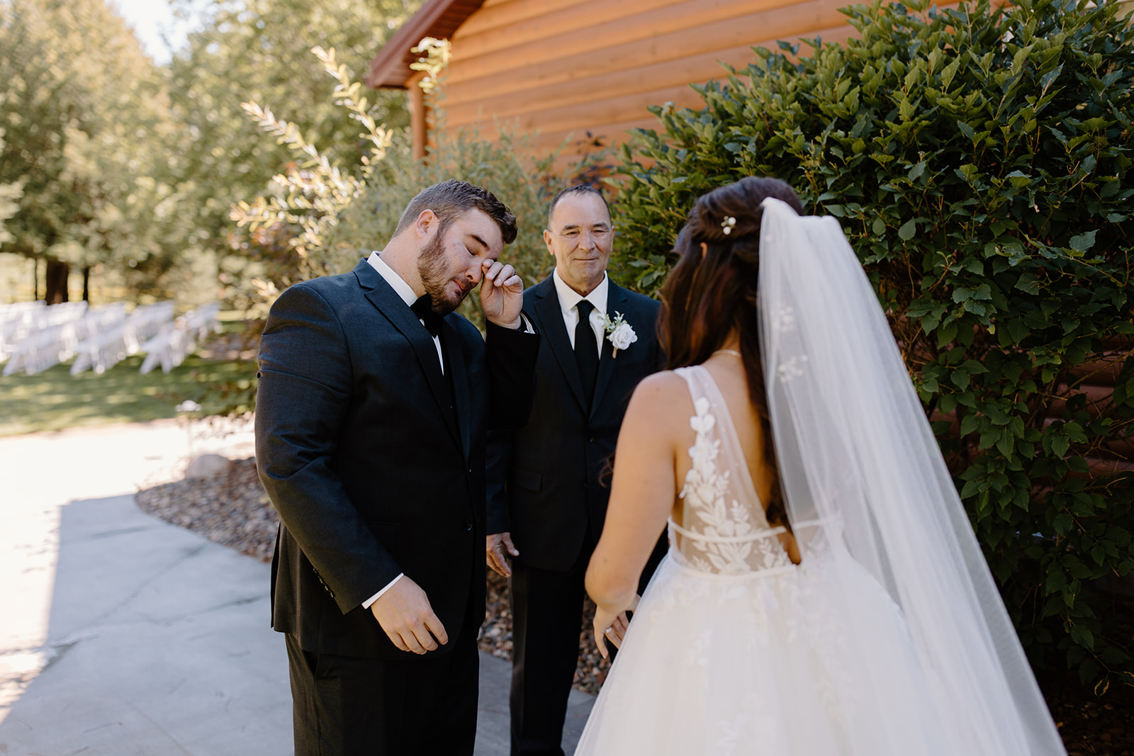 Two men cry as they look at the bride