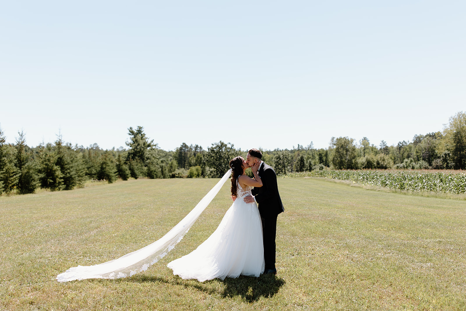 Bride and groom hug in an open field