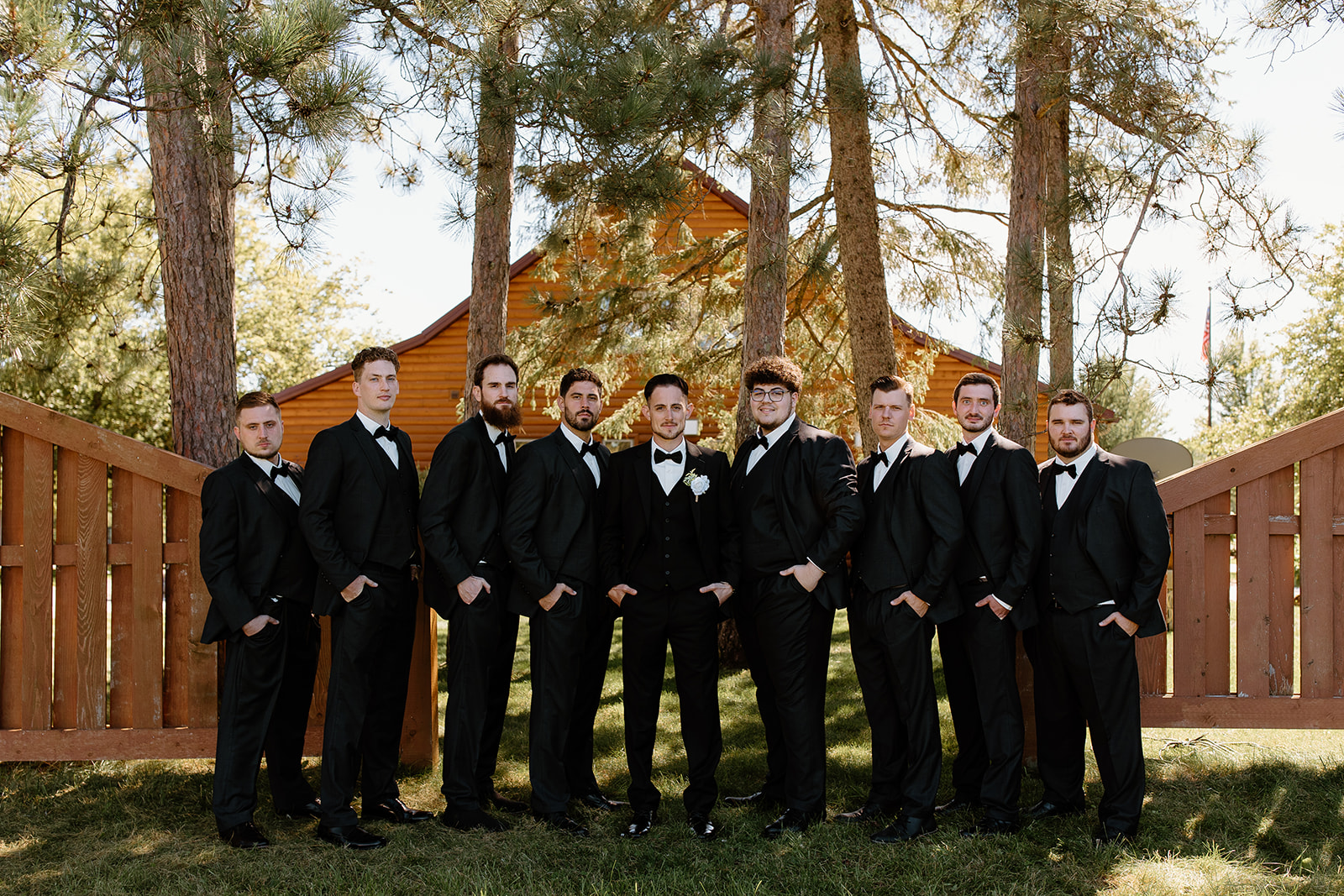 Groomsmen smile in a line in front of the camera
