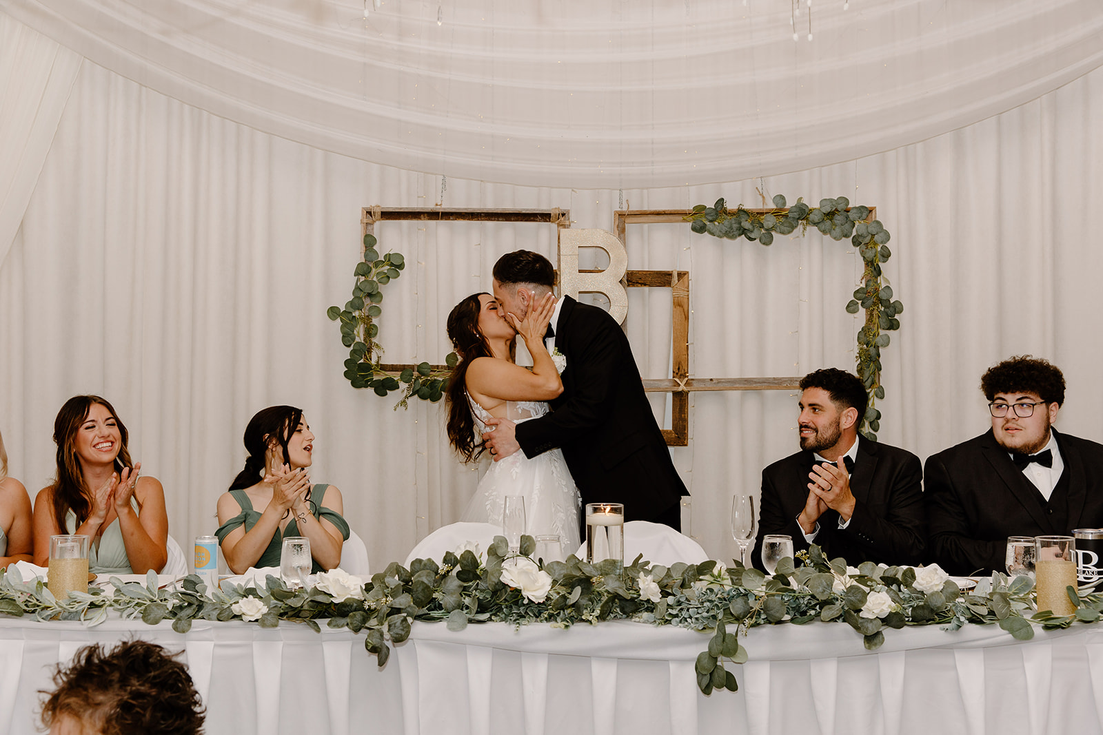 Bride and groom share a kiss at their wedding table