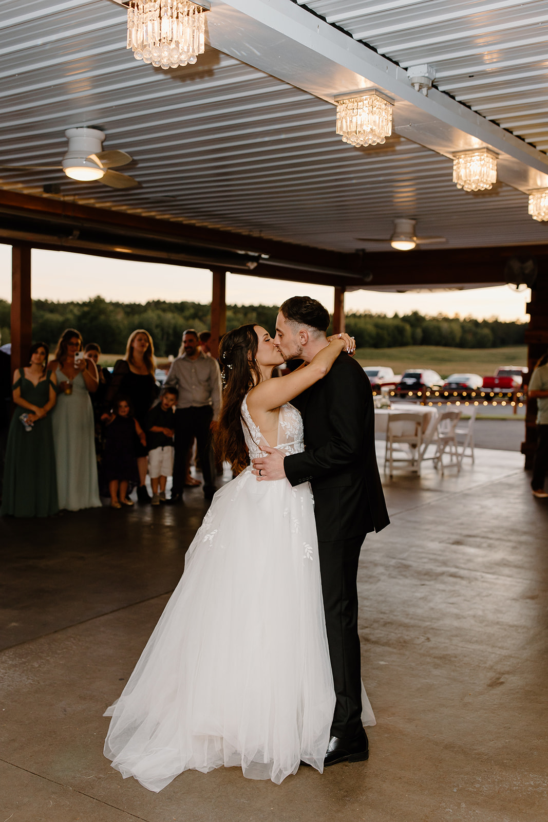 Bride and groom dance underneath lights