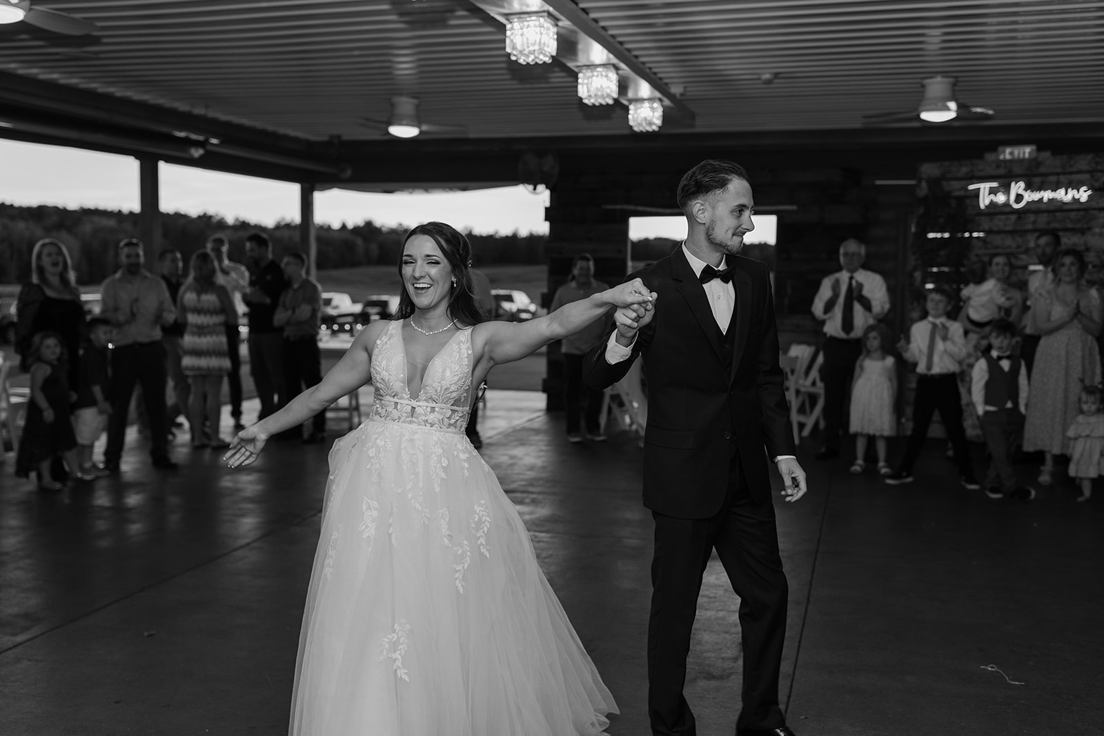 Bride and groom dance underneath lights