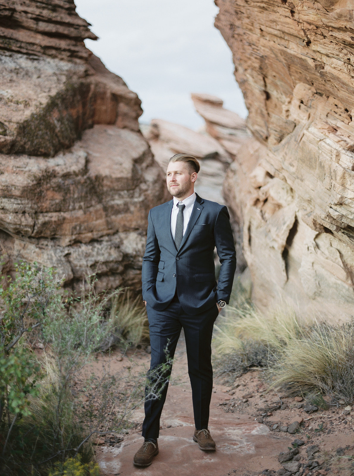 Portrait of the groom in a dark blue suit during his zion national park elopement 