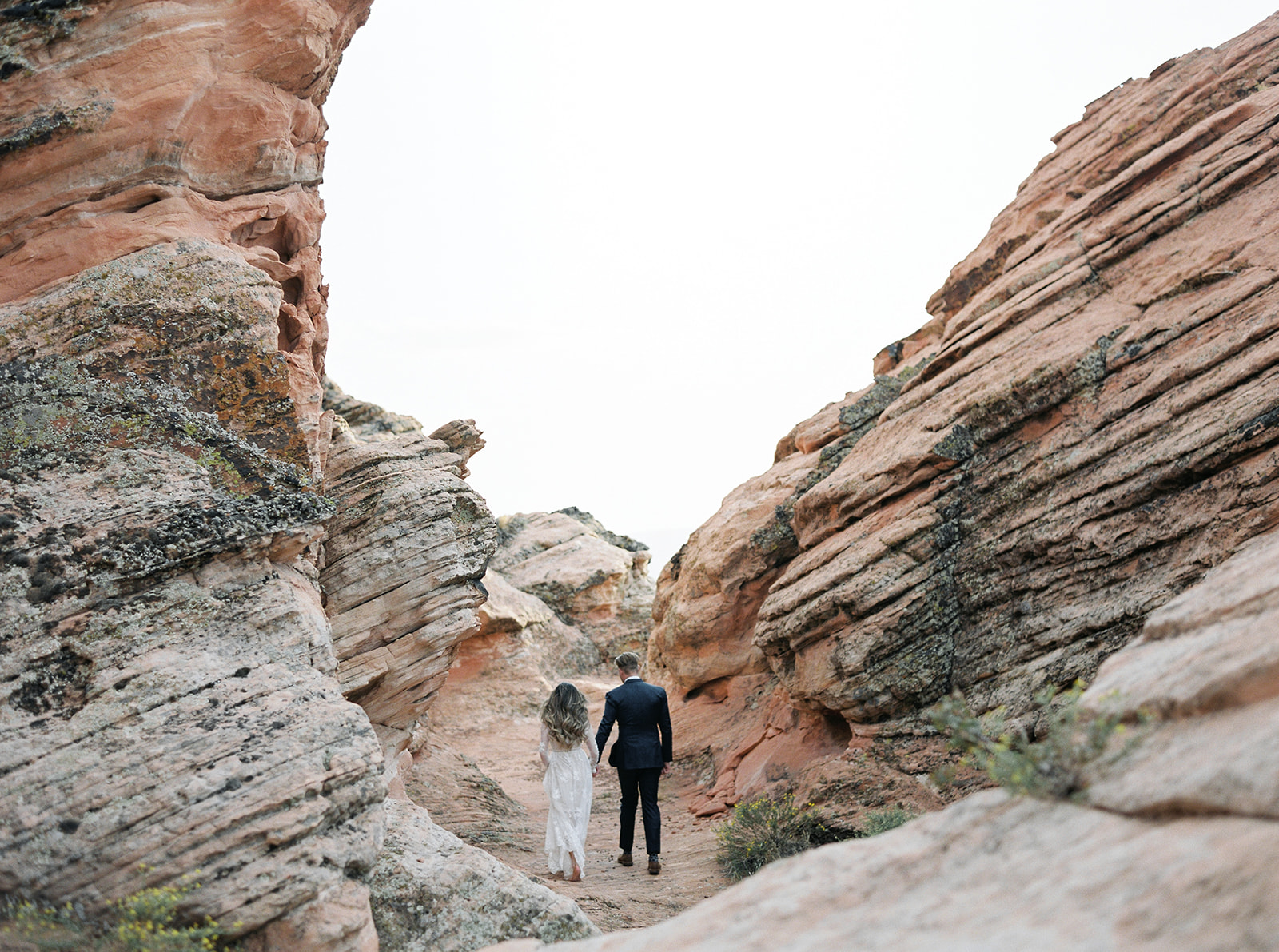 Bride and groom during exploring the red rock formations during their Zion National Park Elopement. 
