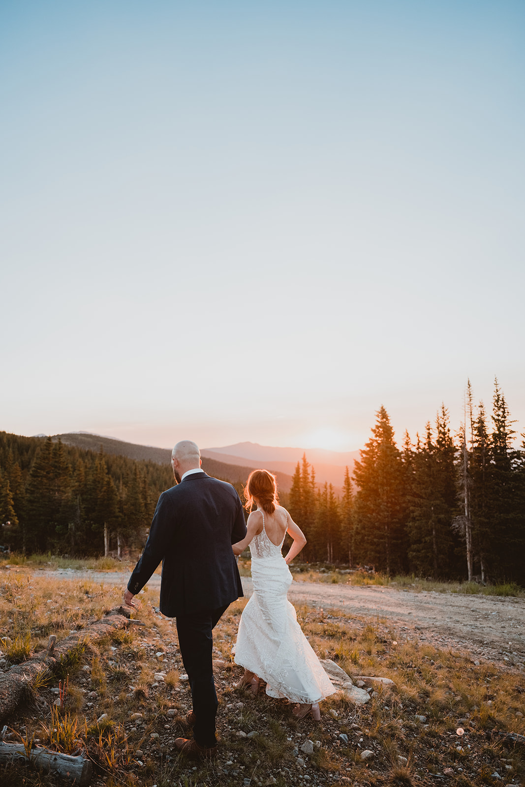 Bride and Groom walk at sunset in the mountains in Winter Park Colorado 