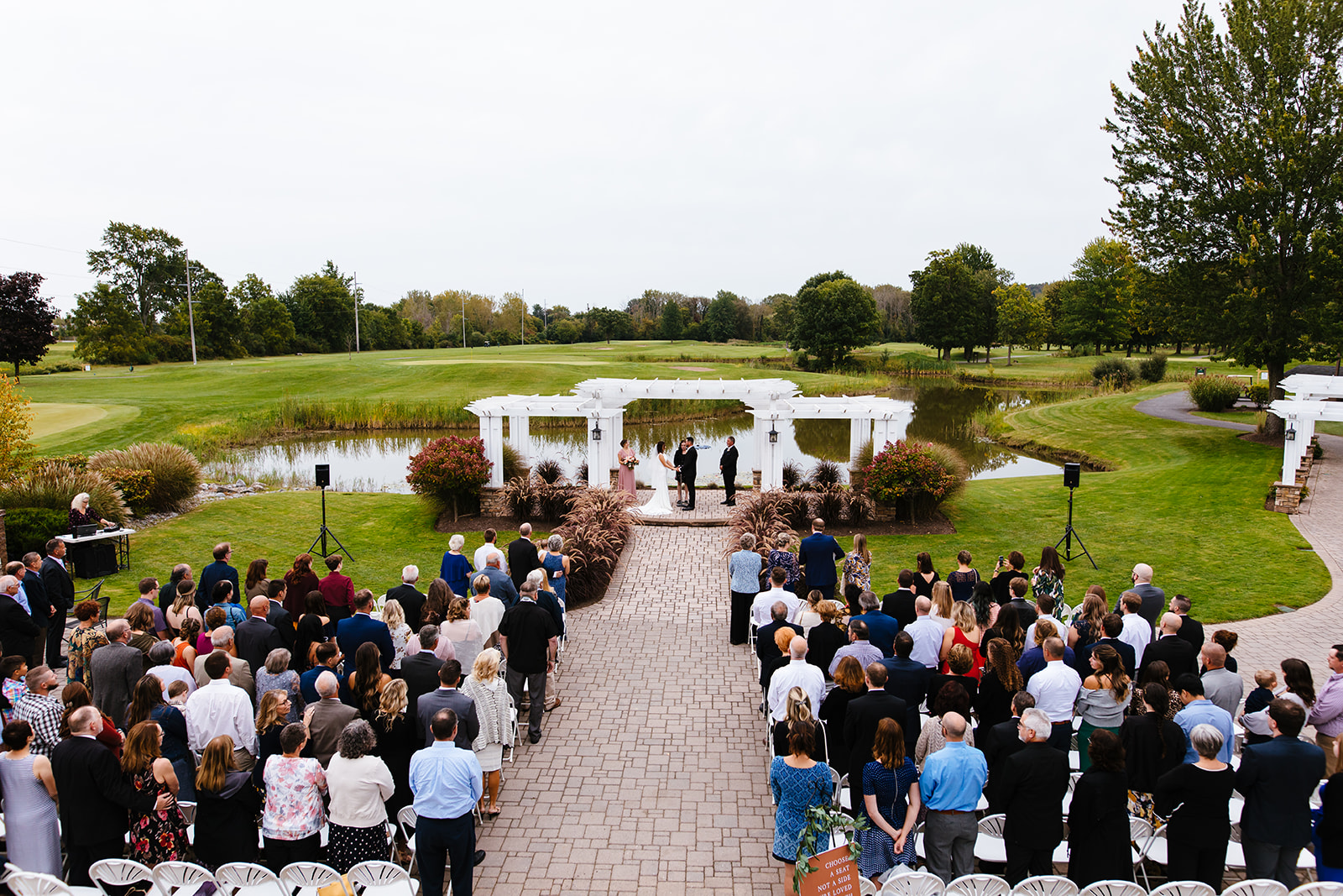 Wide photo of bride and groom getting married at Traditions at the Links in Syracuse NY.