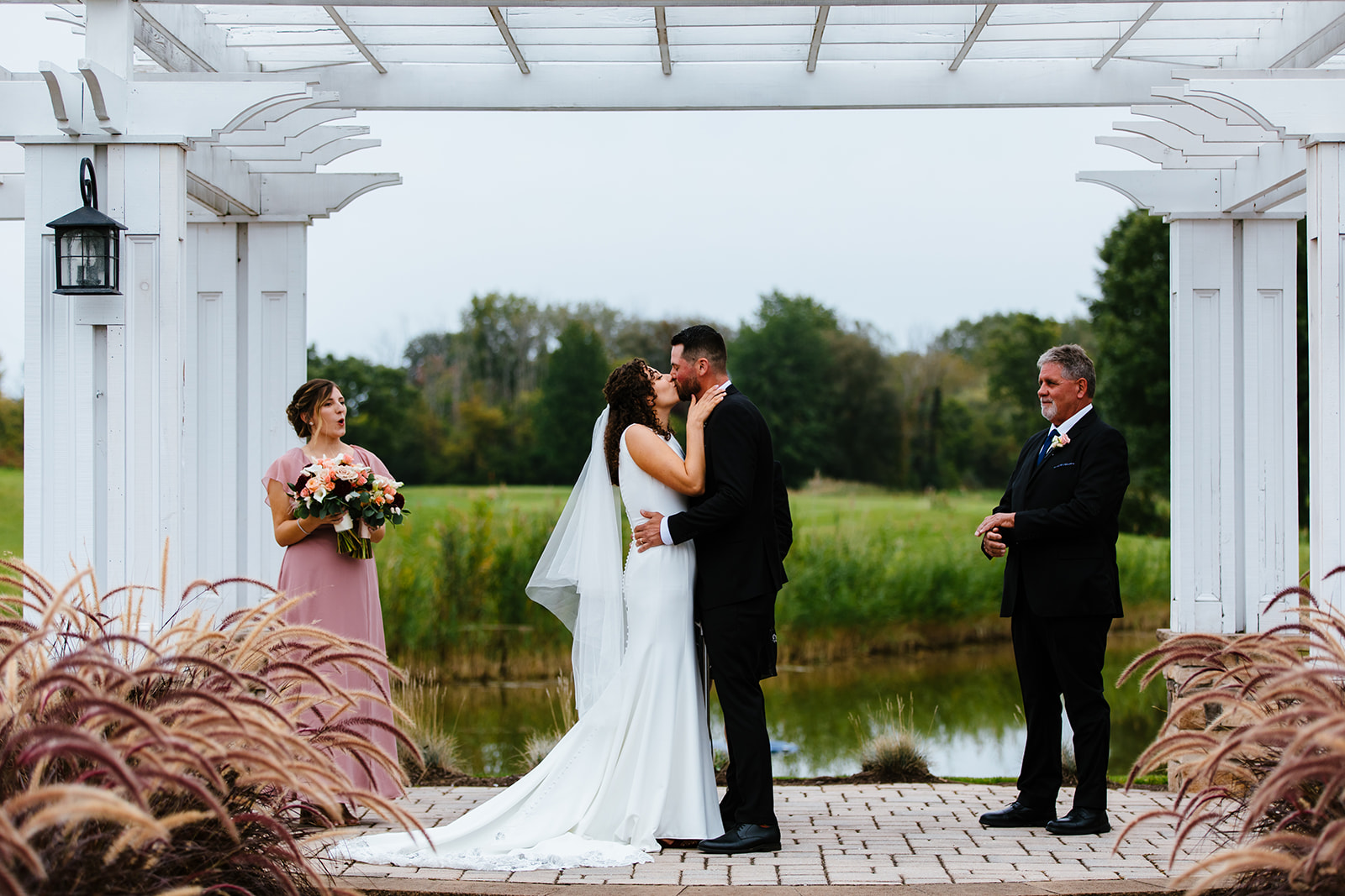 Bride and groom share a first kiss at their wedding. The wedding took place at Traditions in Syracuse, NY.