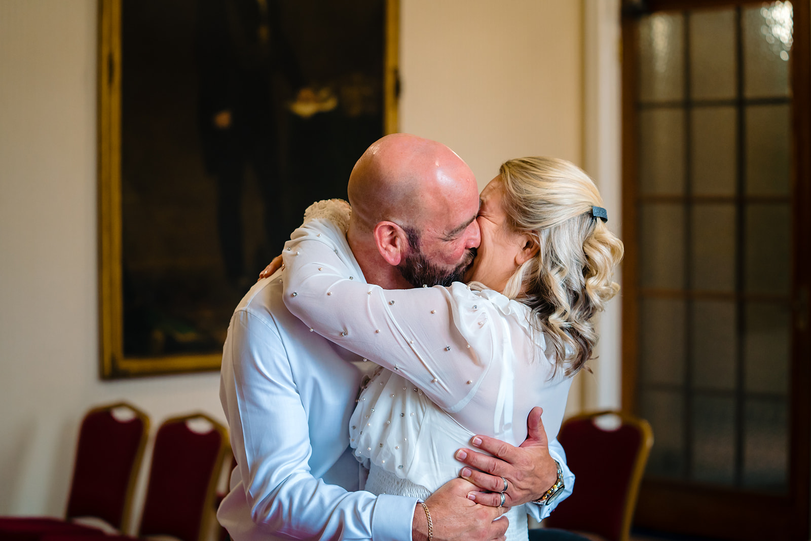 husband and wife kiss after getting married in leeds civic hall